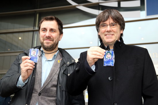 Former Catalan cabinet members Toni Comín and Carles Puigdemont hold up their MEP accreditations on December 20, 2019 (by Nazaret Romero)